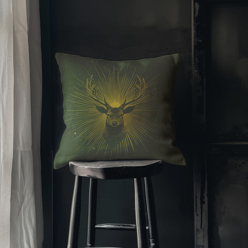 A pillow cover with a majestic stag illustrated in metallic gold on deep moss green fabric. Gleaming rays extend outward from the deer's head, with small golden stars dispersed throughout.